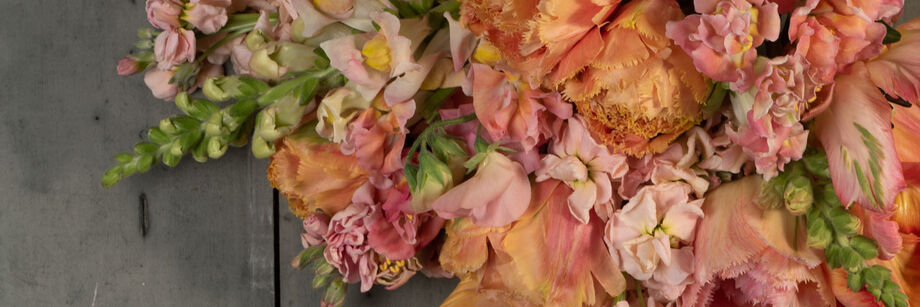 A bouquet of flowers in peach shades with tints of lavender.