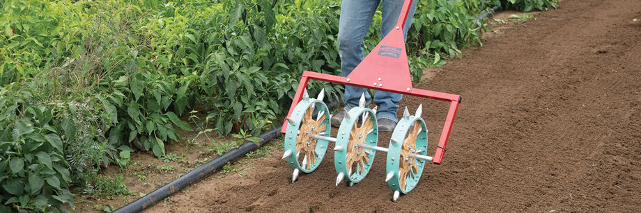 A three-row rolling dibbler being used to prepare a seedbed prior to transplanting.