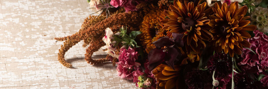 A bouquet of flowers in shades of brown, rose, and copper.