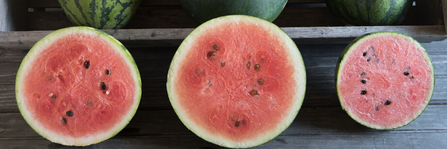 Three watermelons shown cut open with bright pink interiors.