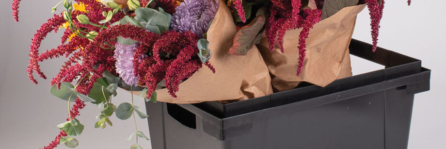 Flower bouquets in a black plastic Procona Valencia container.