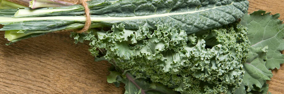 Bunch of kale, grown from Johnny's kale seeds, and displayed on a wooden cutting board.