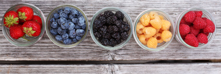 Five jars filled with berries grown from Johnny's fruit plants and fruit seeds.