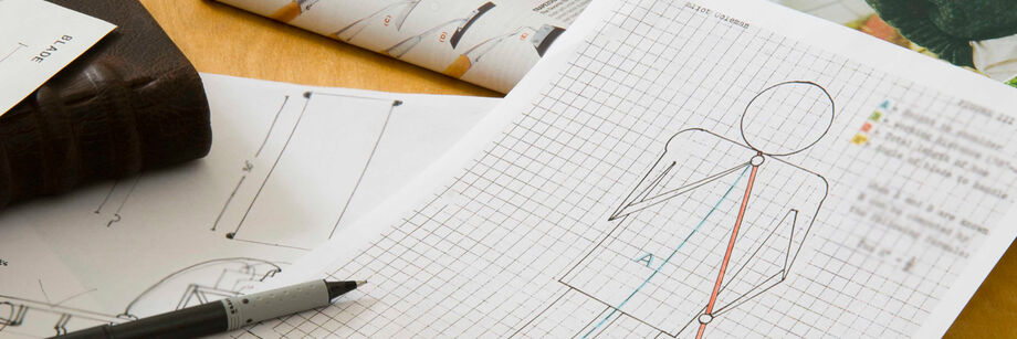 A desk with drafting and design paperwork.