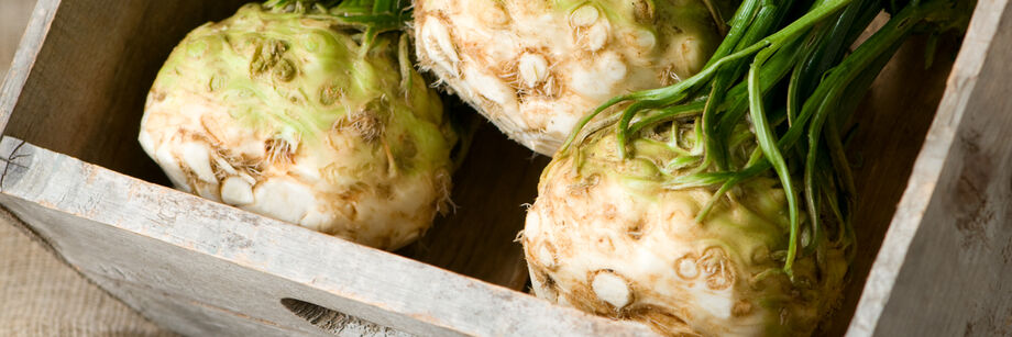 Three celeriac roots in a wooden dish.