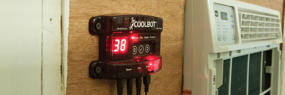 A CoolBot and air conditioner mounted on the wall of an on-farm cold storage room