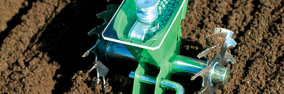Overhead view of the Glaser seeder being used to seed peas, which are visible in the seed hopper.