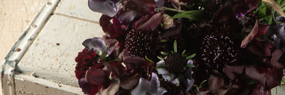 Bouquet of flowers in deep maroon, almost black shades.