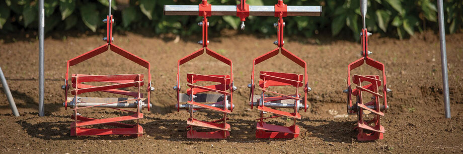 Four wheel weeders lined up in a row according to the size of the wheel, from large to small.