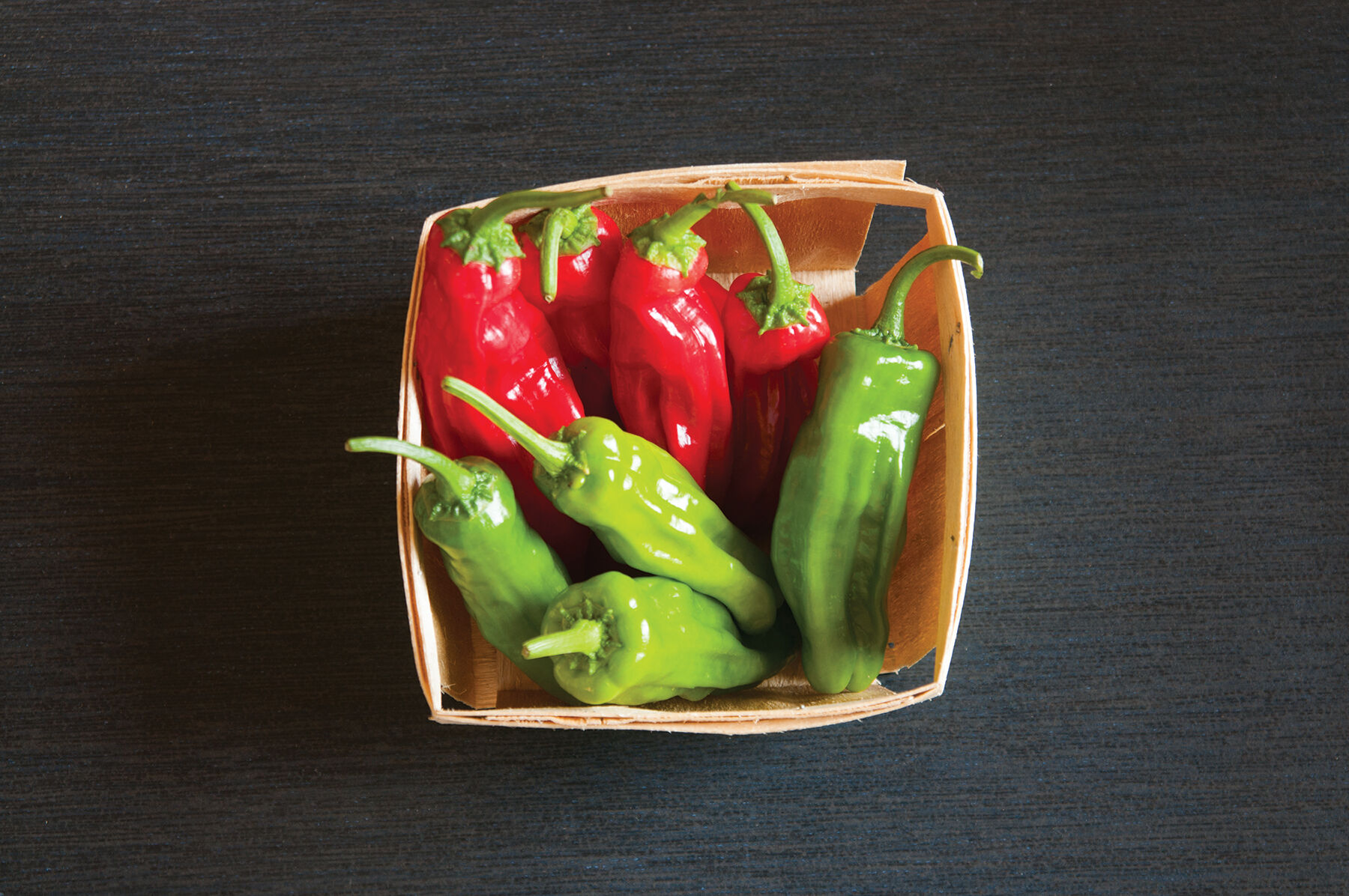 Quart-sized container of red and green Mellow Star Shishito peppers Sweet Peppers