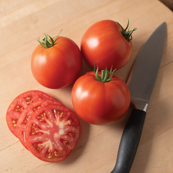 Three tomatoes sliced with knife