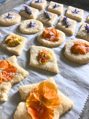 orange pansy (viola) flowers as decorations on top of sugar cookies